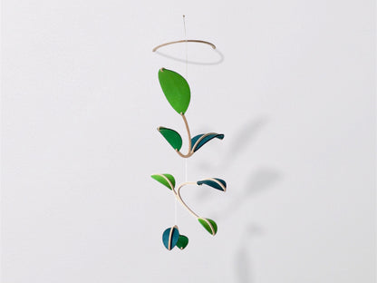 Wall Hanging Plant Mobile, Kinetic Artificial Plant Wall Art for Planted living Space, Leafy Office & Nature Nursery decor. Alternative Gift

Felt Leaf Mobile can be used as a ceiling hanging mobile or as a wall hanging plant mobile. 

Elevate your space with this versatile Midcentury Modern Mobile, designed for both nurseries and adult living areas. Crafted from natural wood with deep teal and green shades of soft felt, this handmade nursery mobile embodies a minimalist and Scandinavian aesthetic.